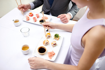 Image showing close up of couple eating sushi at restaurant