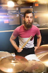 Image showing male musician playing cymbals at music store