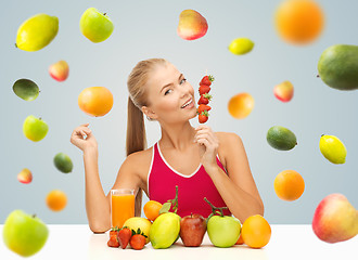 Image showing woman with juice and fruits eating strawberries