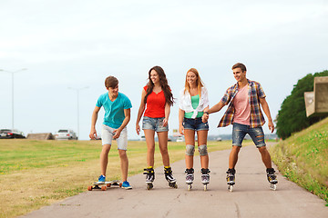 Image showing group of smiling teenagers with roller-skates