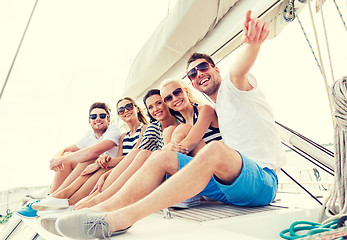 Image showing smiling friends sitting on yacht deck