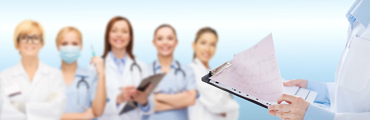 Image showing female doctor holding clipboard with cardiogram