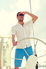 Image showing young man in sunglasses steering wheel on yacht