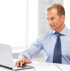 Image showing miling businessman working in office