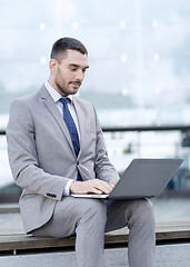 Image showing businessman working with laptop outdoors
