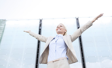 Image showing young smiling businesswoman over office building