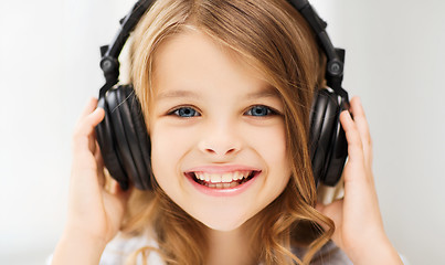 Image showing little girl with headphones at home