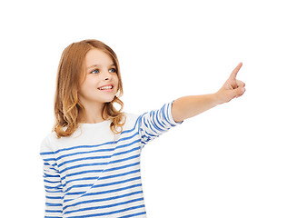 Image showing smiling girl pointing at virtual screen