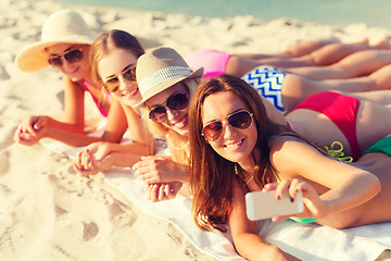 Image showing group of smiling women with smartphone on beach