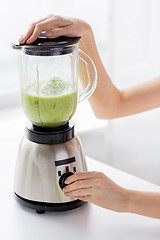 Image showing close up of woman hands with blender making shake
