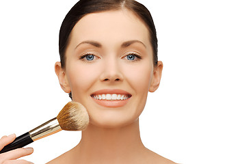 Image showing woman applying powder foundation with brush