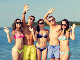 Image showing smiling friends in sunglasses on summer beach