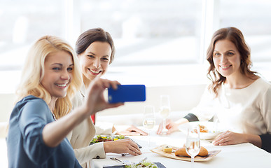 Image showing women with smartphone taking selfie at restaurant