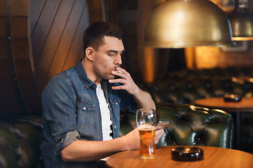 Image showing man drinking beer and smoking cigarette at bar