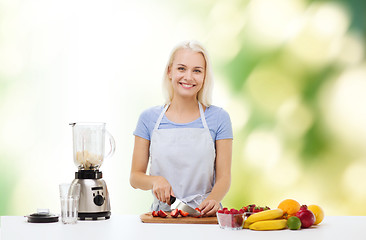 Image showing smiling woman with blender preparing shake