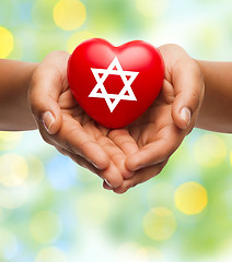 Image showing close up of hands holding heart with jewish star