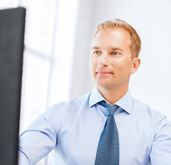 Image showing businessman with calculator, computer and papers