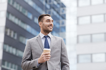 Image showing young smiling businessman with paper cup outdoors