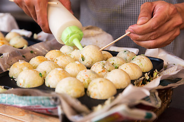 Image showing cook stuffing dough or rice balls at street market