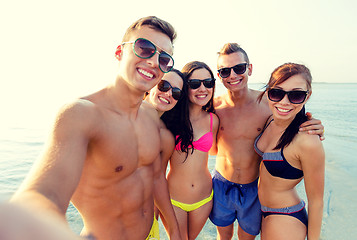 Image showing group of smiling friends making selfie on beach
