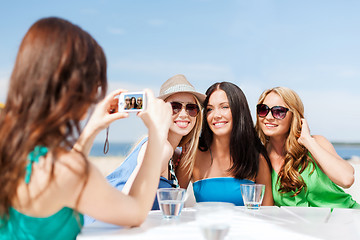 Image showing girls taking photo in cafe on the beach