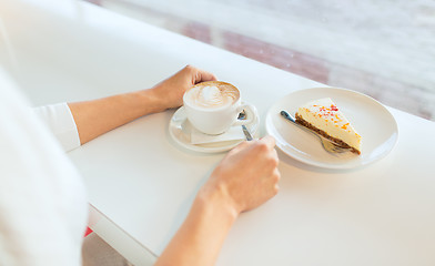 Image showing close up of woman hands with cake and coffee