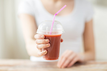 Image showing close up of woman holding cup with smoothie