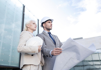 Image showing businessmen with blueprint and helmets