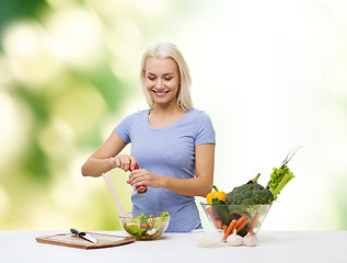 Image showing smiling woman cooking vegetable salad