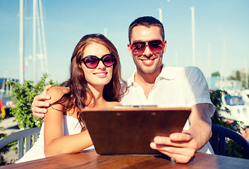 Image showing smiling couple with menu at cafe