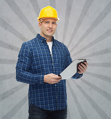 Image showing smiling male builder in helmet with clipboard