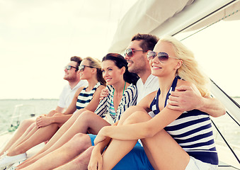 Image showing smiling friends sitting on yacht deck