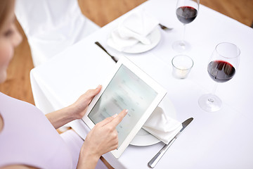 Image showing close up of woman with tablet pc at restaurant