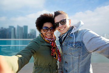 Image showing happy teenage couple taking selfie in singapore