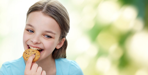 Image showing smiling little girl eating cookie or biscuit