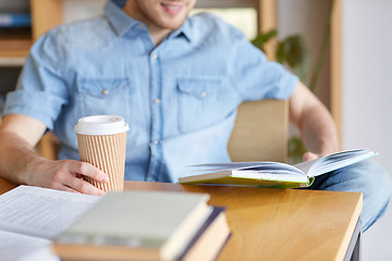 Image showing happy student reading book and drinking coffee