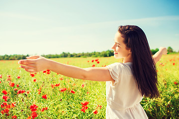 Image showing smiling young woman on poppy field