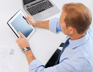 Image showing businessman with tablet pc and papers in office