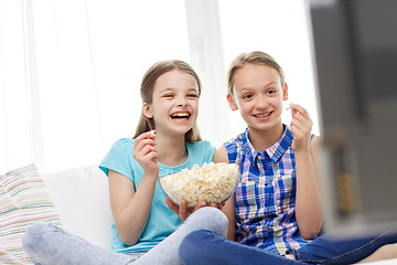 Image showing happy girls with popcorn watching tv at home