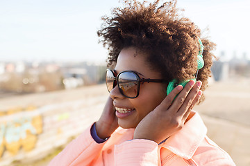 Image showing happy young woman in headphones listening to music