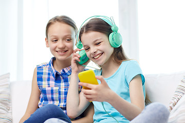 Image showing happy girls with smartphone and headphones