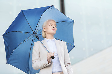 Image showing young serious businesswoman with umbrella outdoors