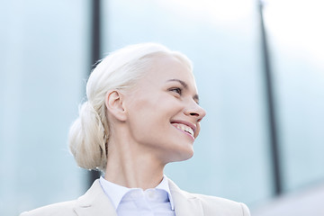 Image showing young smiling businesswoman over office building