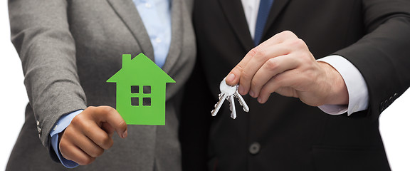 Image showing businessman and businesswoman holding green house