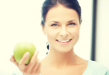 Image showing woman in the kitchen with an apple