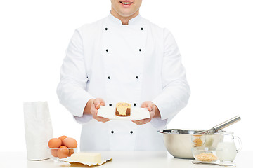 Image showing close up of happy male chef cook baking dessert 