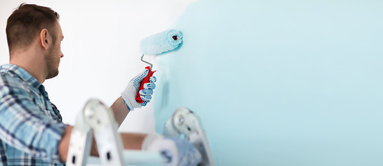 Image showing close up of male in gloves holding painting roller