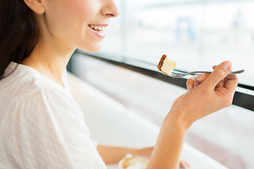 Image showing close up of woman eating cake at cafe or home