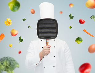 Image showing male chef cook covering face with grill pan