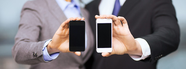 Image showing businessman and businesswoman with smartphones